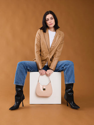 Beige glossy crossbody bag with gold chain strap and front square clasp