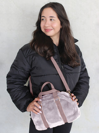 Sherpa Boston bag in light mauve worn crossbody, with adjustable strap and top handles