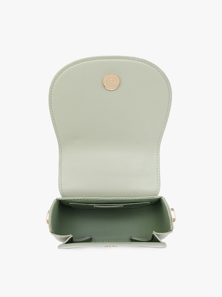 Vegan mini saddle bag in light sage, open top showing interior lining and snap closure.