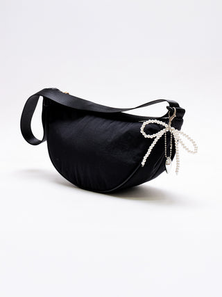 Beaded bow bag charm with white pearl beads on a black handbag