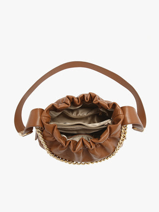 Ruched vegan bucket bag in brown with ruched opening and beige interior lining visible