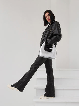 Model carrying silver metallic vegan shoulder bag with short handles