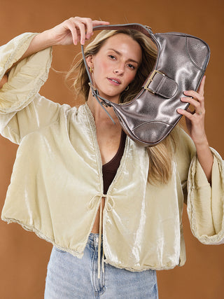 Madrid vegan buckle shoulder bag in metallic silver held by model, with shoulder strap and buckle